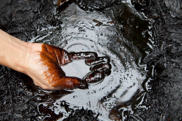 A hand touching crude oil. Photo: iStock.